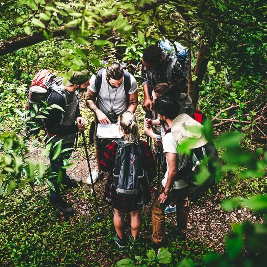 Groep collega's bekijkt een kaart in het bos van Yport bij camping La Chenaie