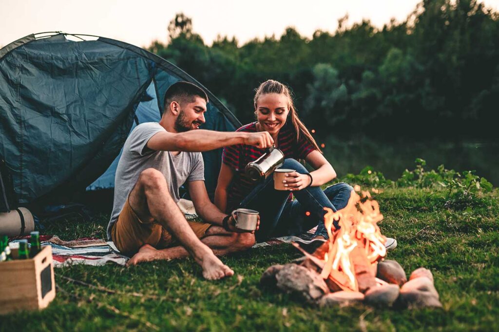 couple tente camping cafe feu